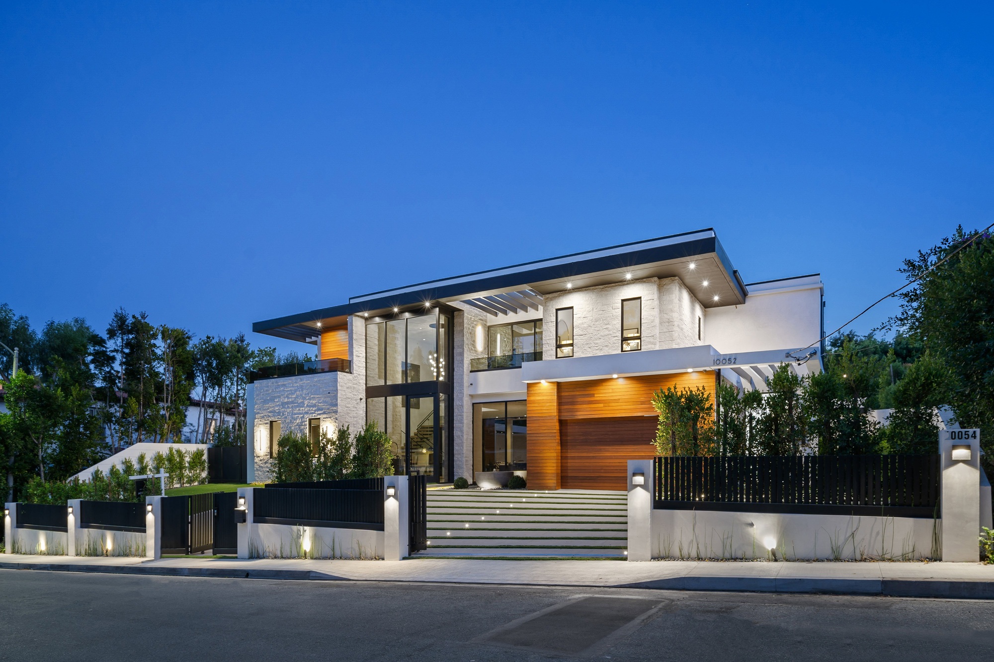 Modern luxury house exterior illuminated at dusk.