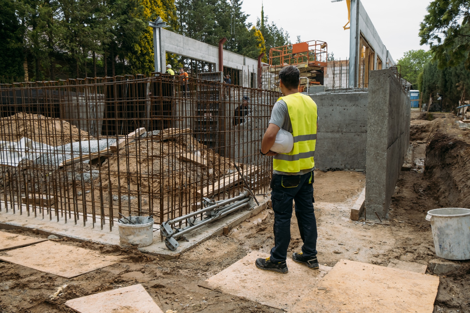 Person with helmet looking at construction site building house